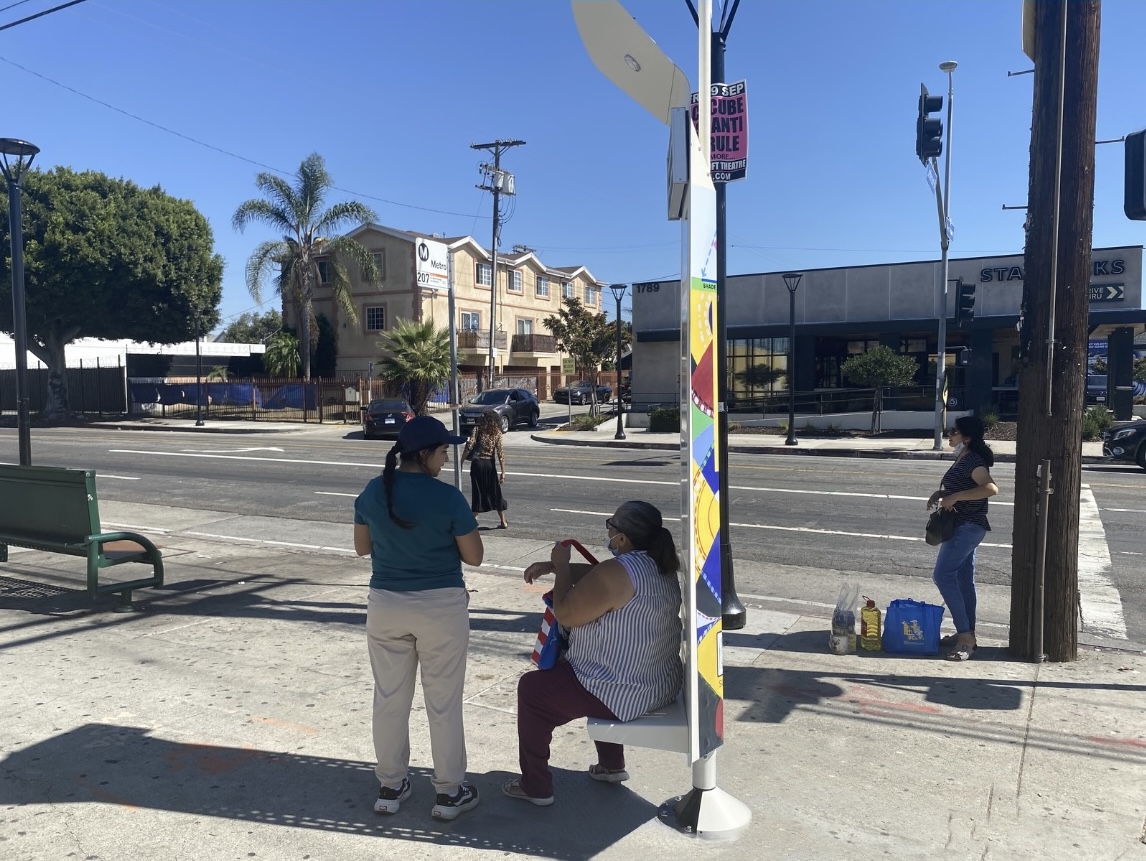 Women Waiting on Bus Stop after Grocery Shopping